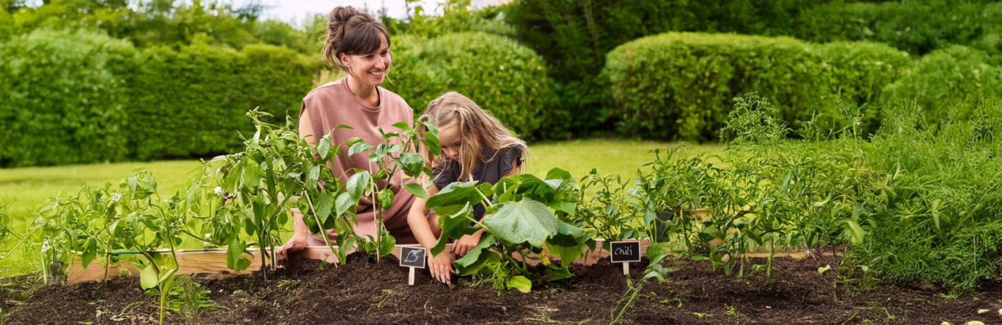 Mutter und Tochter arbeiten im Bodenbeet.