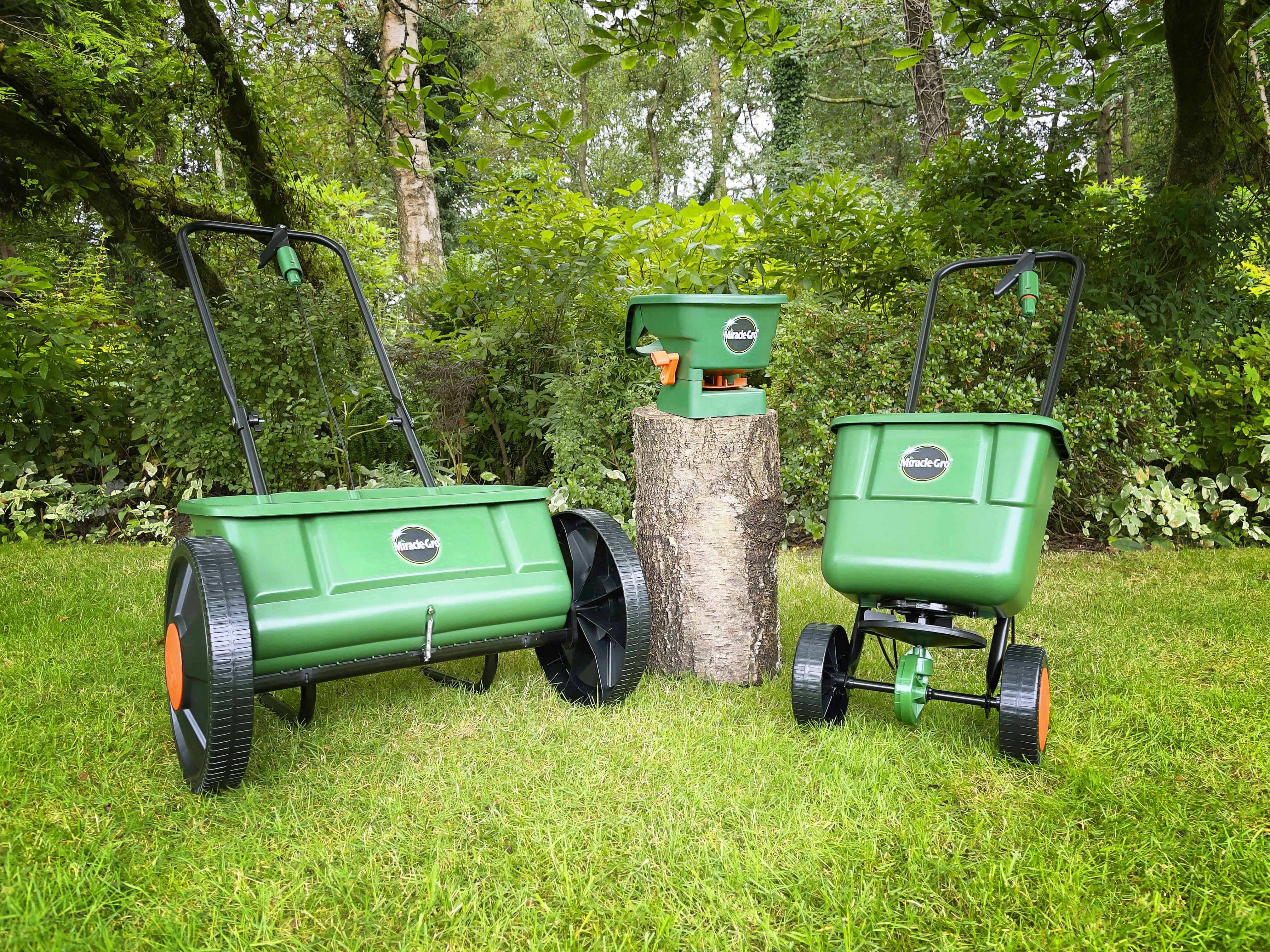 Miracle-Gro lawn spreader range displayed on a lawn.