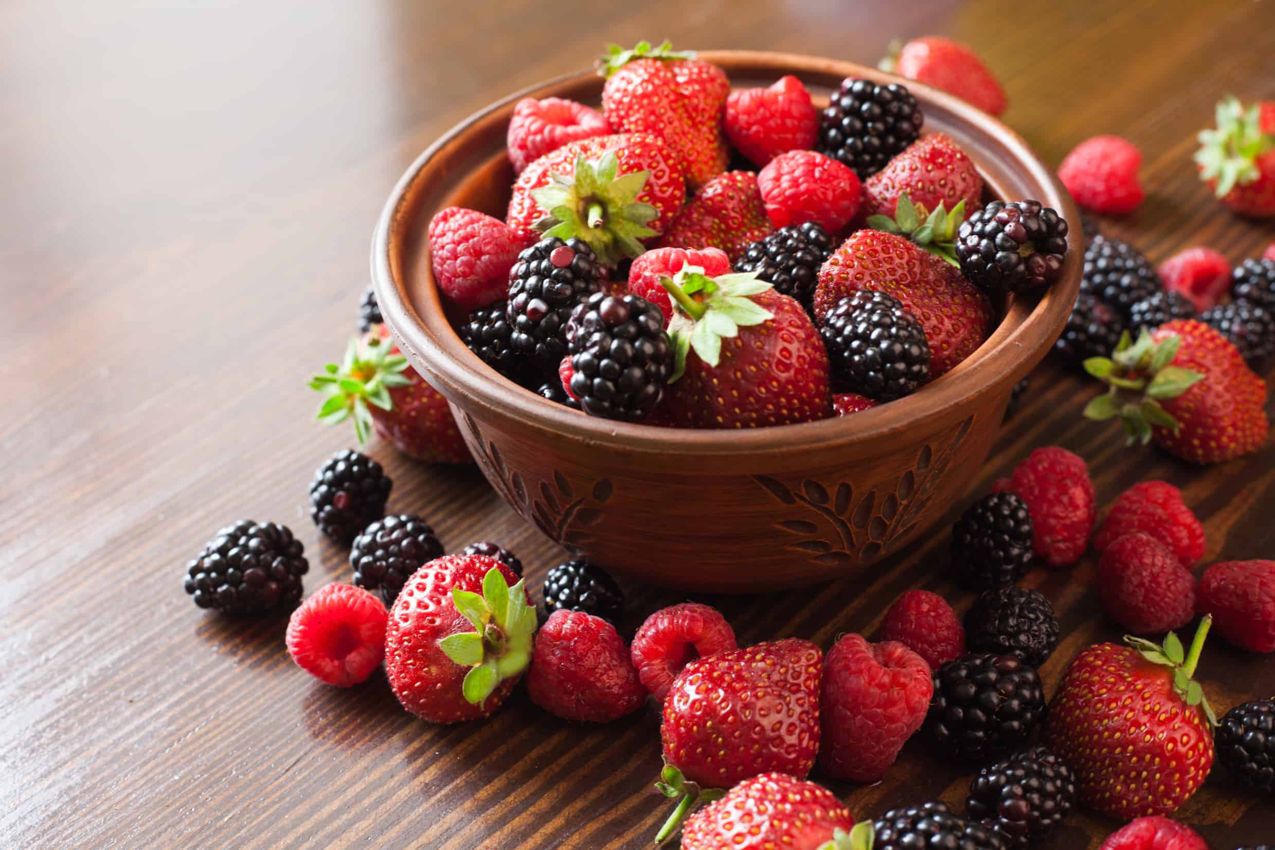 Red fruits in a wooden bowl