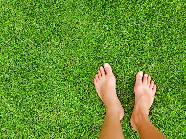 Person standing on the lawn with no shoes on