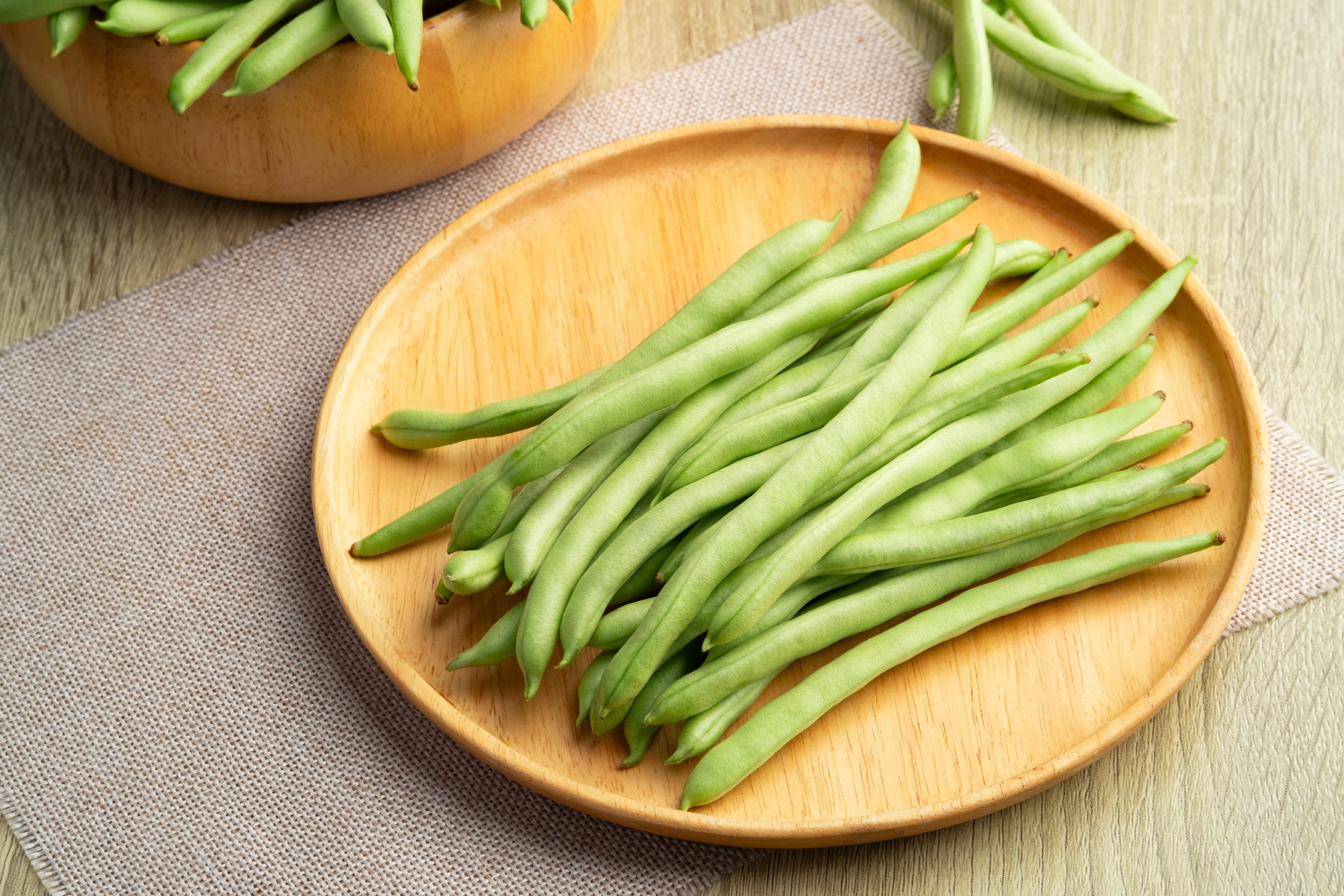 Haricots verts sur une assiette en bois