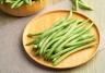 Haricots verts sur une assiette en bois
