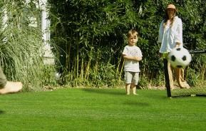 Kinder spielen Fußball im Garten