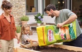 Familie arbeitet im Hochbeet