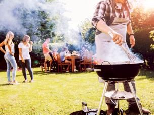 A group of friends enjoying a summer barbeque on a lawn.