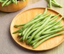 Haricots verts sur une assiette en bois