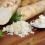 Sections of harvested horseradish root and grated horseradish on a wooden table