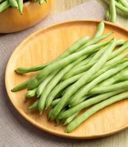 Haricots verts sur une assiette en bois