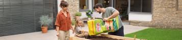 Familie arbeitet im Hochbeet