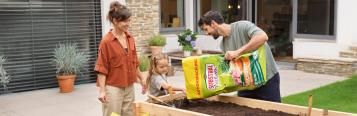 Familie arbeitet im Hochbeet