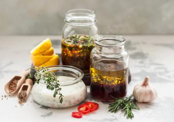Glass Jars filled with various herbs on marble table